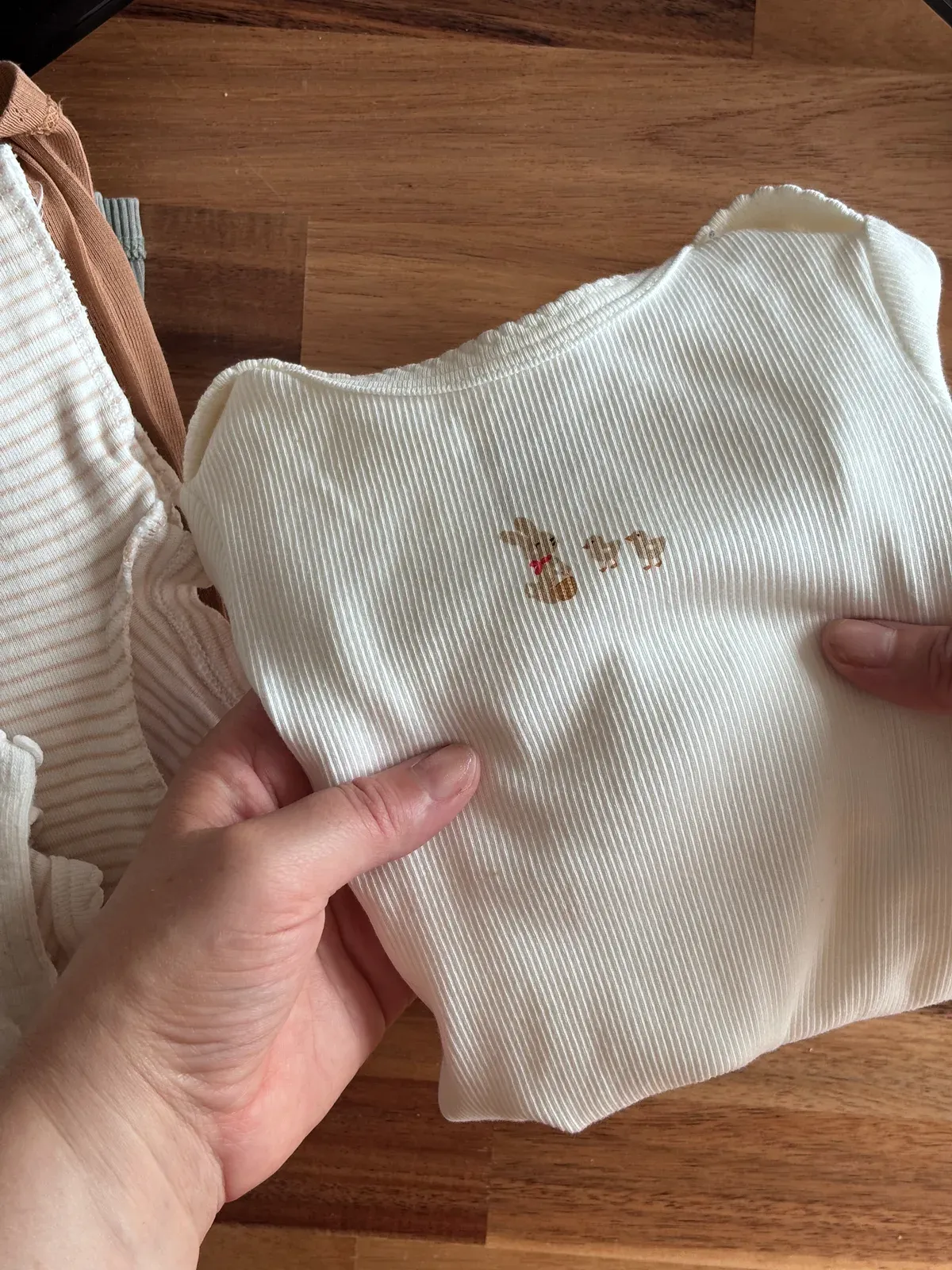 Vêtements de bébé pliés avec soin pendant une visite Le Relais Post-partum